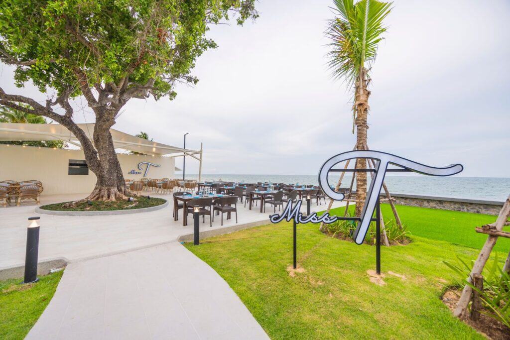 Breathtaking outdoor dining area at Aviyana Hua Hin Hotel with ocean views, lush greenery, and modern oceanfront seating for a luxurious seaside experience.