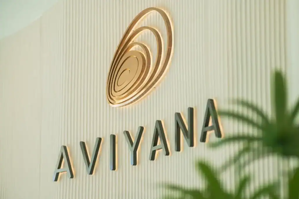 Modern hotel logo of Aviyana Hua Hin on a cream-colored textured wall, featuring a stylish spiral design and elegant 3D lettering. Perfect for showcasing the luxury and contemporary style of the hotel.